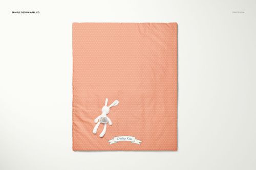 Baby fleece patchwork quilt mockup in peach with tiny dots, displayed flat on light background beside stuffed bunny.