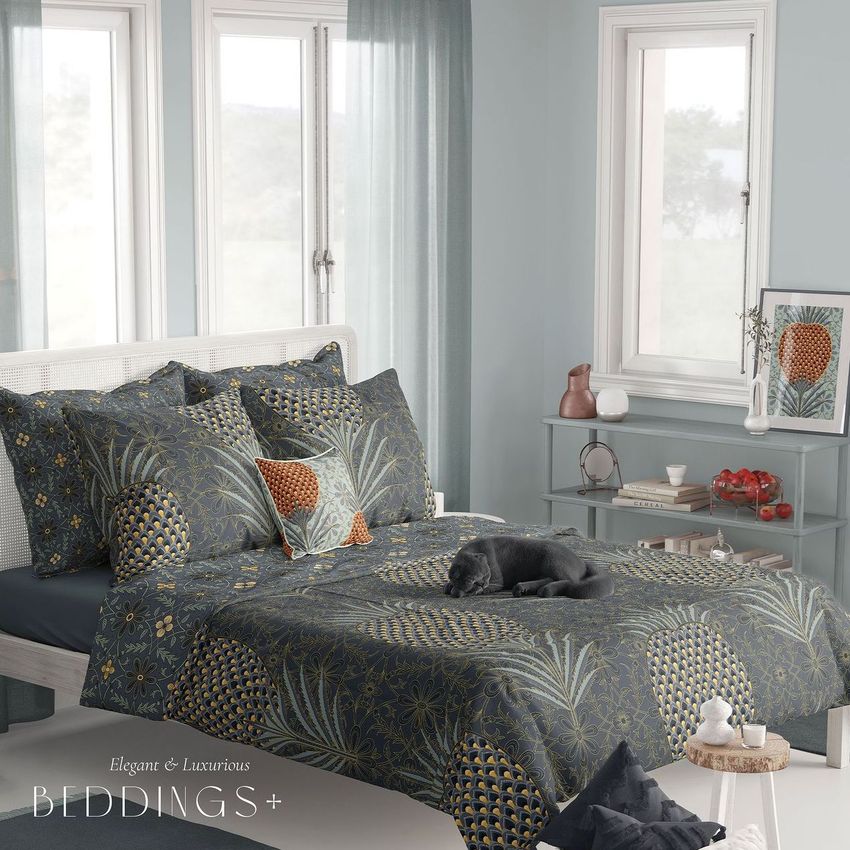 Boho bedroom bedding mockup featuring a bed with patterned dark blue and gold linens, decorative pillows, and a small dog lying on the bed.