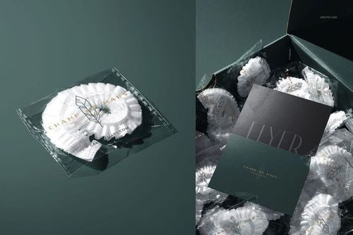 Hotel shower cap in a clear plastic wrapper with gold logo, shown on a dark green surface and inside a box.