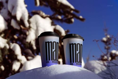Winter-themed PSD mockup featuring two drinkware cups on a snowy surface, with dark lids and graphic print.