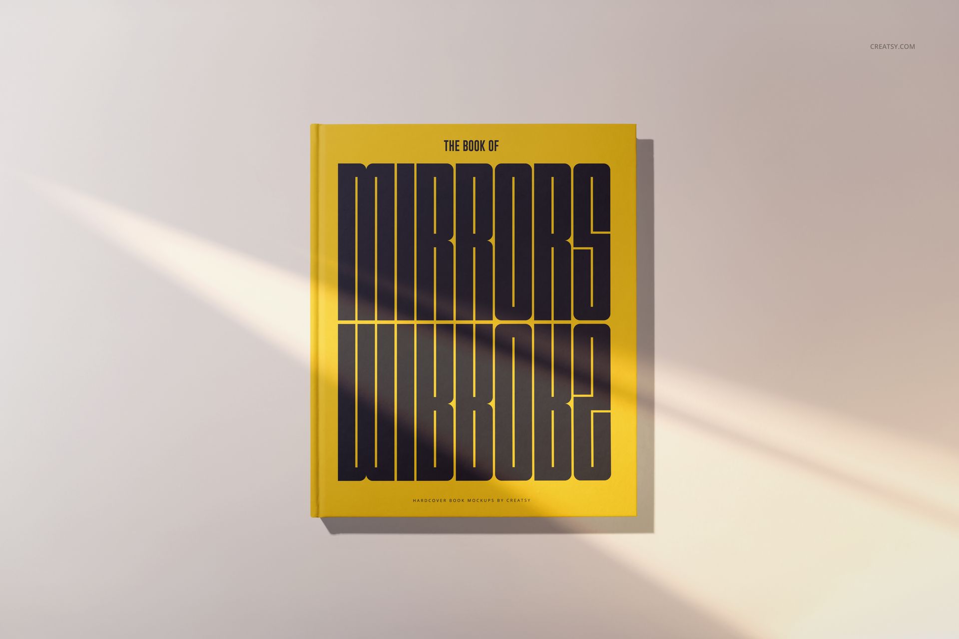Yellow hardcover book mockup with large black lettering on the cover, displayed flat on a neutral background.