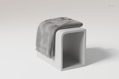Gray fringe blanket draped over a modern white pedestal, shown from a front angle on a plain background.