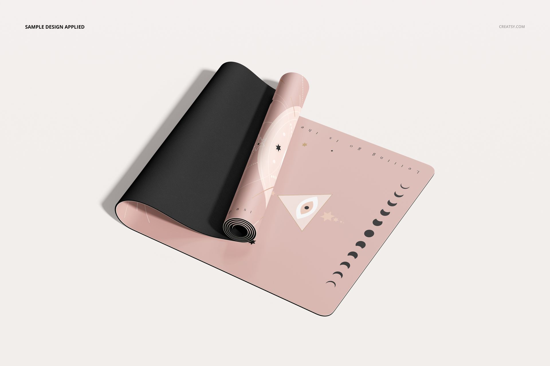 PU leather yoga mat mockup featuring a rolled mat with a pink geometric design and moon phases, top angle view.