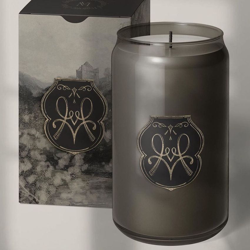 Can glass candle mockup featuring a dark translucent candle jar with an ornate gold emblem, placed in front of a matching illustrated box.