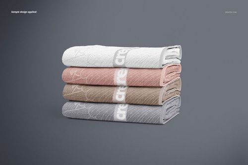 PSD mockup featuring a side view of neatly stacked bath towels in pastel shades and minimal design accents.