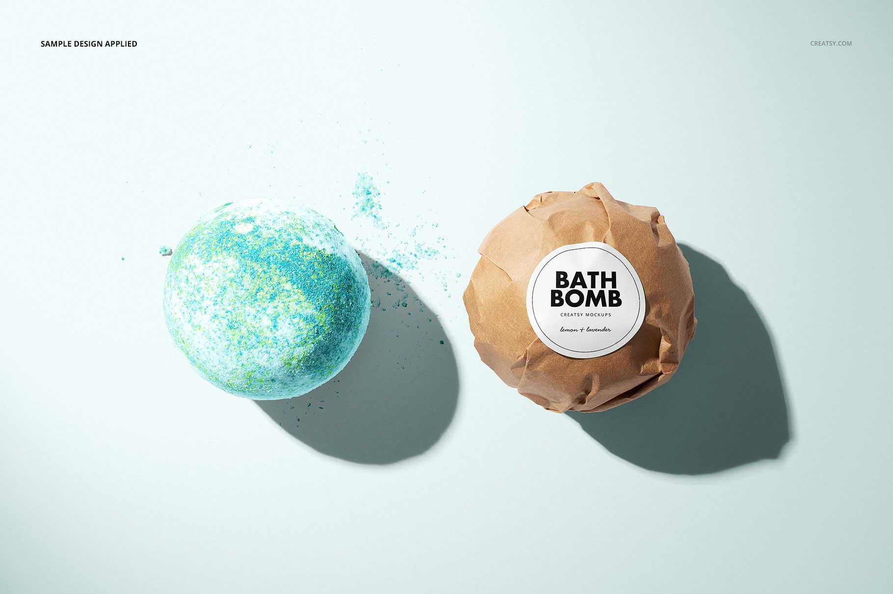 Bath bomb mockup featuring an unwrapped blue-green bath bomb and a brown paper-wrapped bath bomb with a round label.