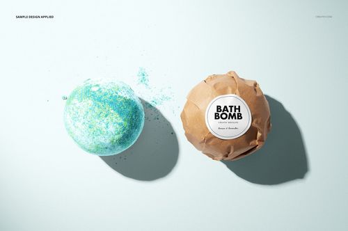 Bath bomb mockup featuring an unwrapped blue-green bath bomb and a brown paper-wrapped bath bomb with a round label.