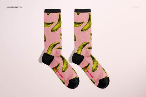 Socks mockup featuring two pink socks with black accents and repeating yellow banana design, displayed flat on light surface.