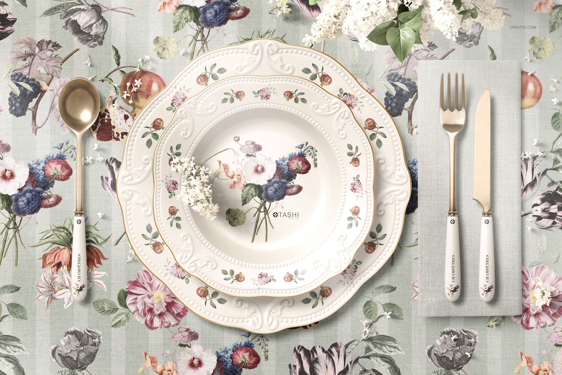 Top view of a classic placemat mockup with a floral patterned plate, napkin, and cutlery on a decorative tablecloth.