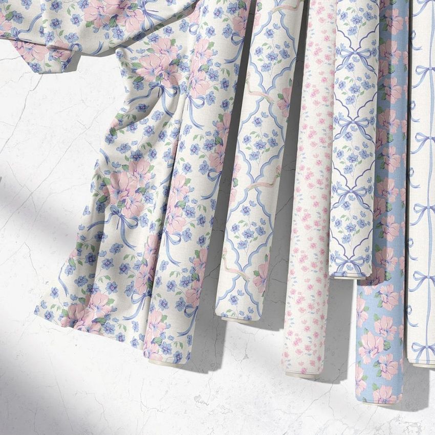 Fabric rolls mockup featuring six rolls with pastel floral and ribbon patterns, arranged on a light marble surface.