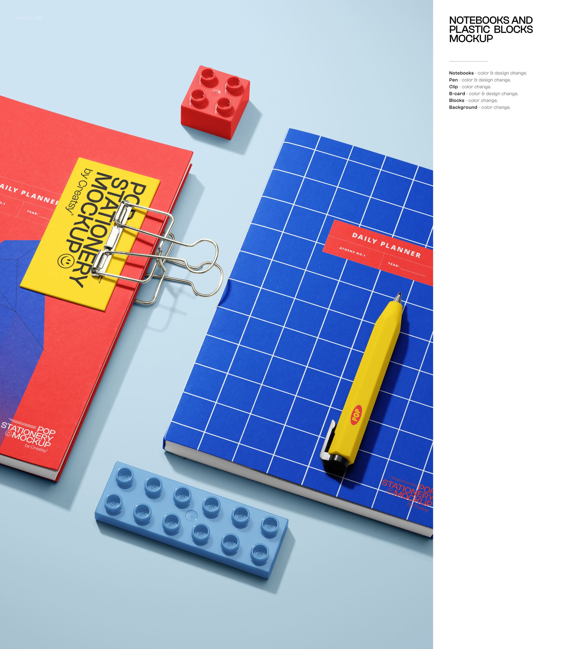 Stationery mockup scene featuring notebooks, pen, binder clip, and plastic building blocks arranged on a pastel blue surface.