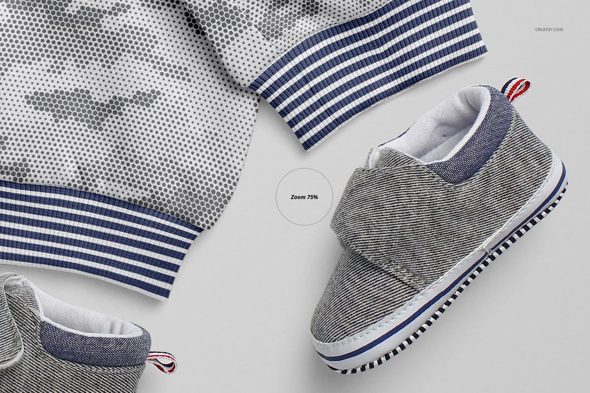 Top view of gray baby sweatpants mockup with blue striped cuffs and a textured baby shoe on a light background.