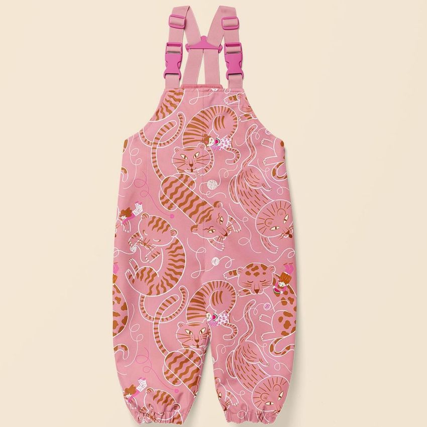 Kids rainwear mockup featuring pink overalls with playful orange cat illustrations and yarn ball accents on a plain background.