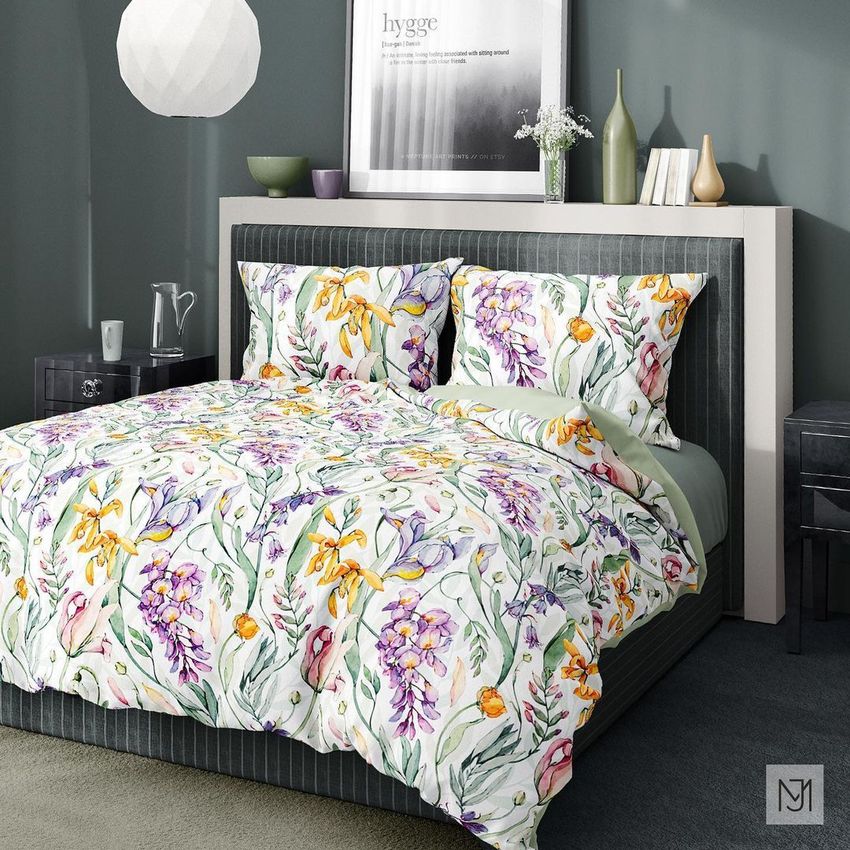 Bedding mockup featuring a botanical floral pattern on a duvet and pillows in a modern bedroom with green walls and framed art.