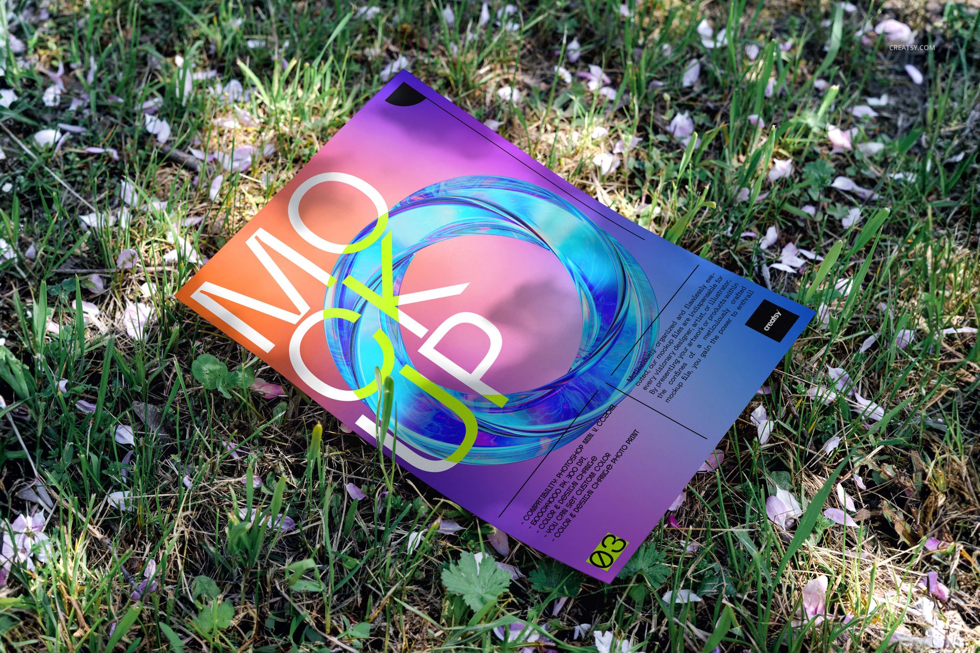 Colorful poster mockup with abstract design lying on grass outdoors, viewed from a slight angle above.