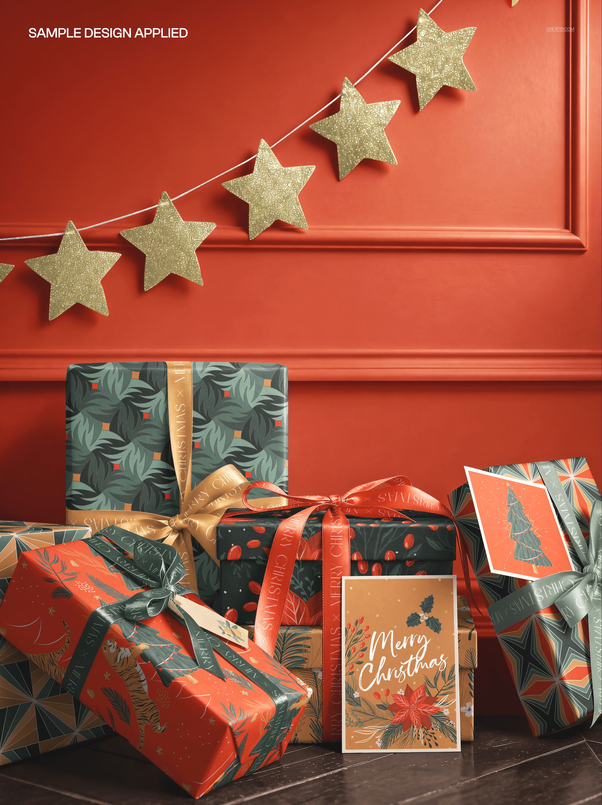 Christmas-themed packaging mockup showing wrapped boxes, greeting cards, and a gold star garland on a red background.
