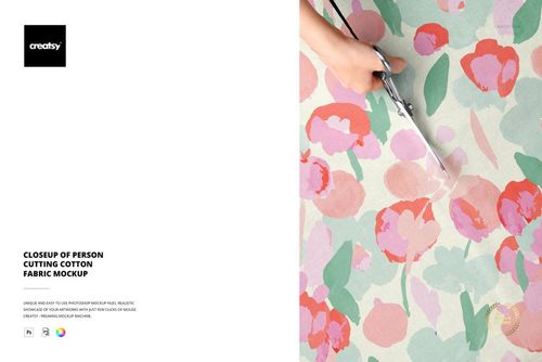 Top view of scissors held by a person slicing through pastel floral cotton fabric, showing mockup details.