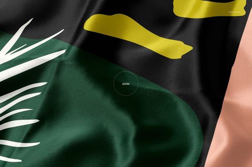 Detailed view of a silk textile mockup displaying smooth folds and a modern pattern in green, black, yellow, and peach.