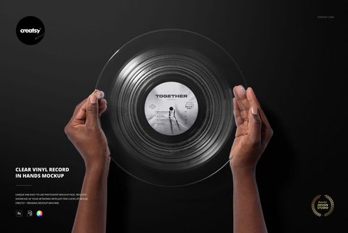 Top view of transparent vinyl record mockup held by hands, with visible label and circular grooves on black surface.