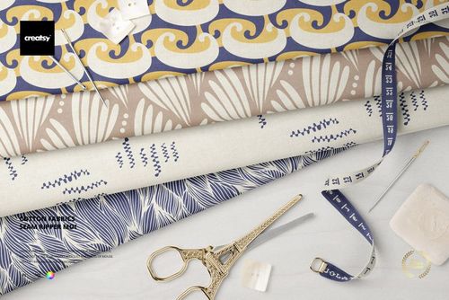 Cotton fabric PSD mockup featuring patterned textiles and tailoring tools like scissors, buttons, and measuring tape.