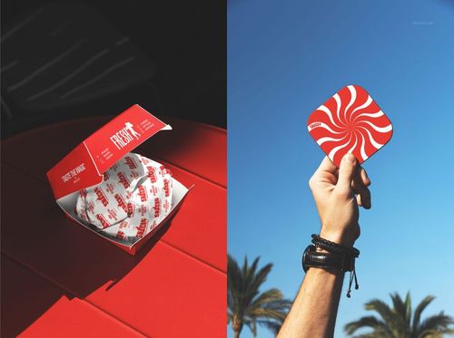 Fast food PSD mockup featuring a red burger box with printed paper and a hand holding a swirl-patterned coaster outside.