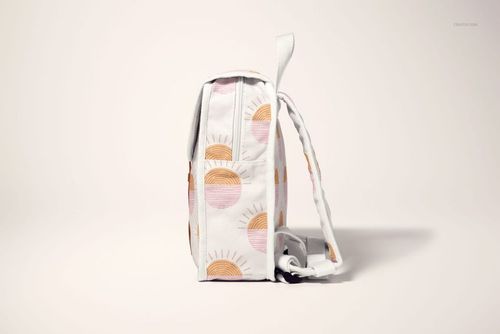 Side view of a kids backpack mockup with white fabric and pastel sun pattern, displayed on a light background.