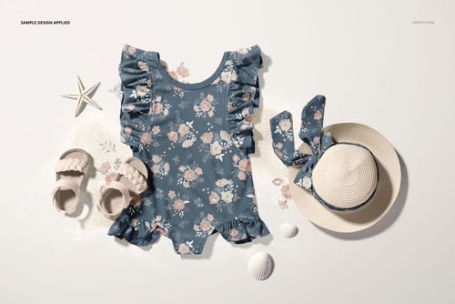 Front view of a baby ruffle swimsuit mockup with a blue floral pattern, surrounded by sandals, a sun hat, and seashells.