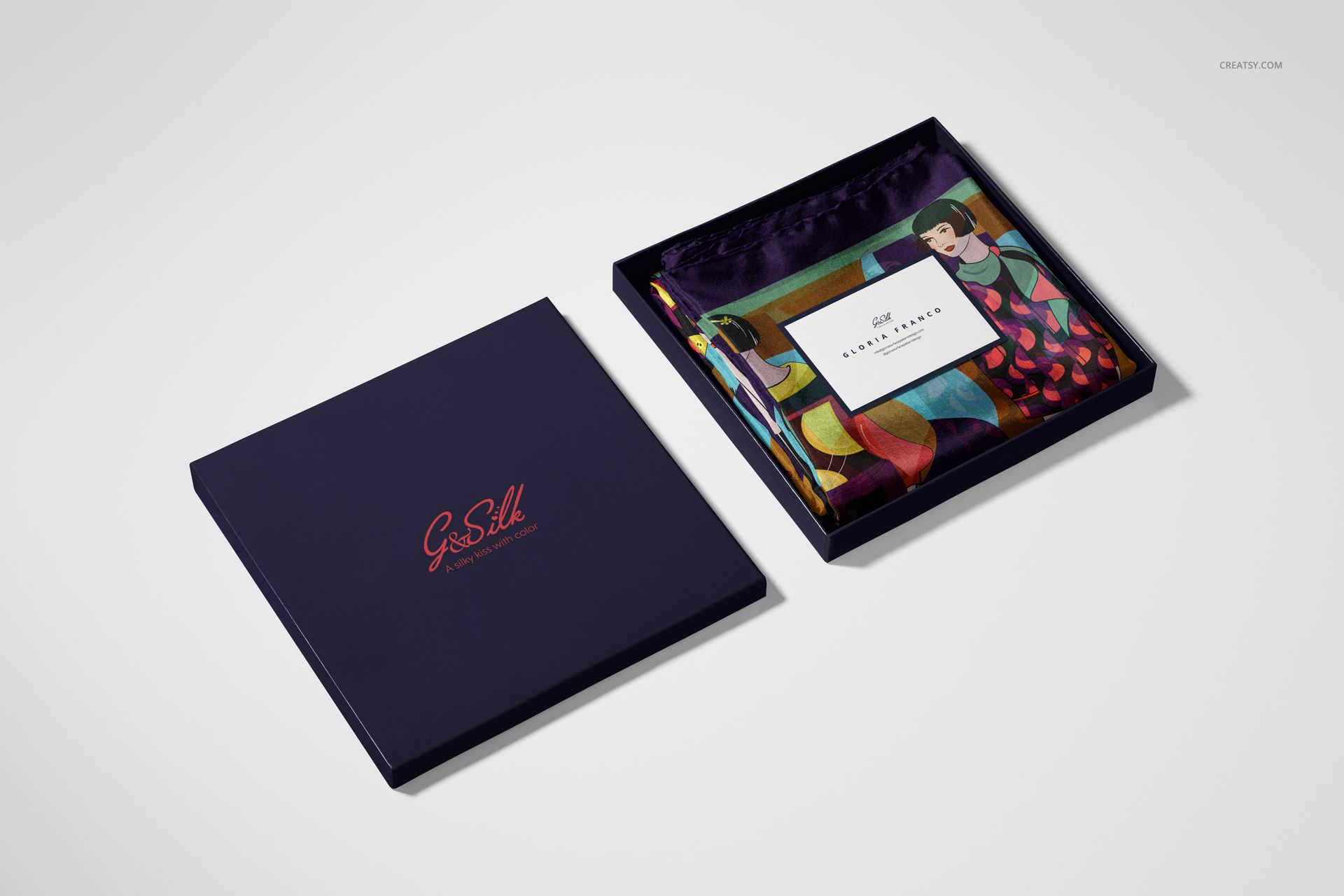PSD mockup of a hand-rolled silk scarf with bold multicolor design, displayed in an open gift box next to its lid.