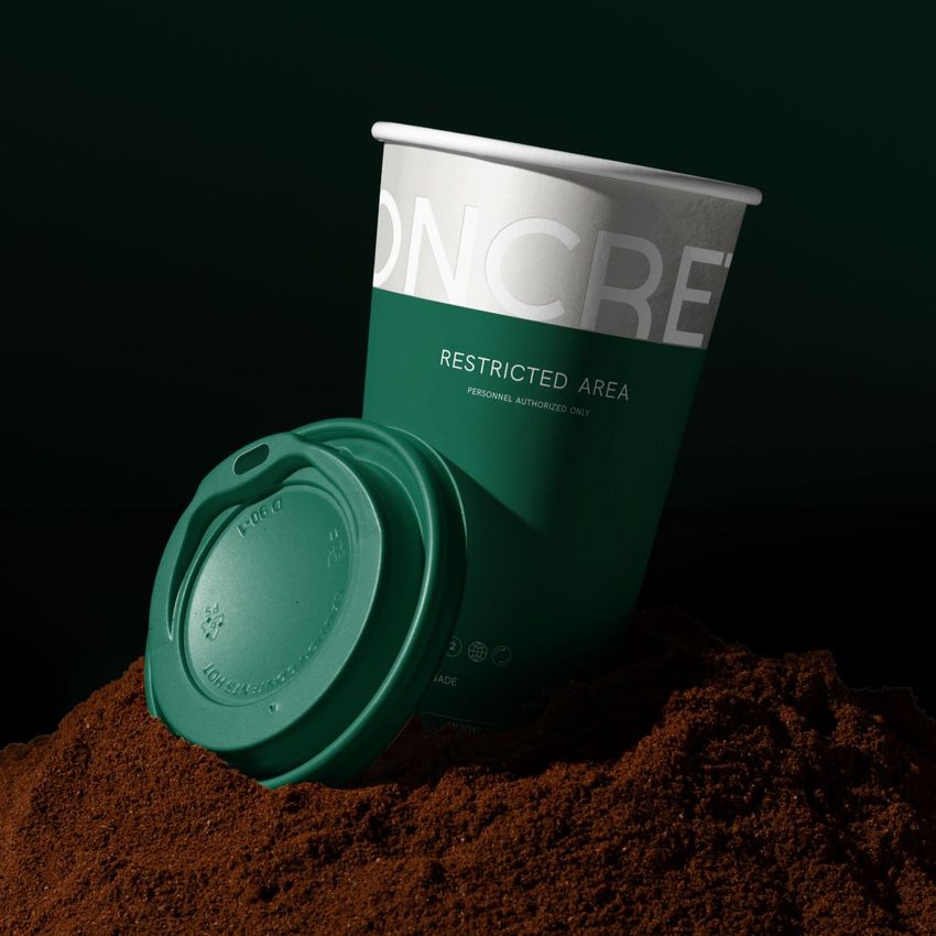 Paper cup mockup with a green lid placed on a mound of ground coffee, featuring bold white and green colors and partial text overlay.