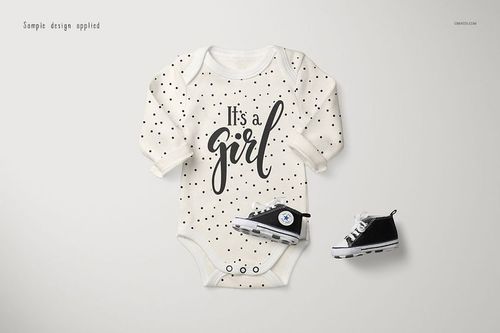 Longsleeve baby onesie mockup with black polka dots and 'It's a girl' text, front view on light background.