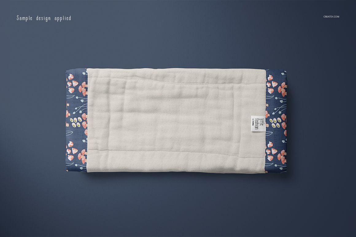 Burp cloth mockup featuring a soft white middle section and navy floral sides, displayed flat against a dark surface.