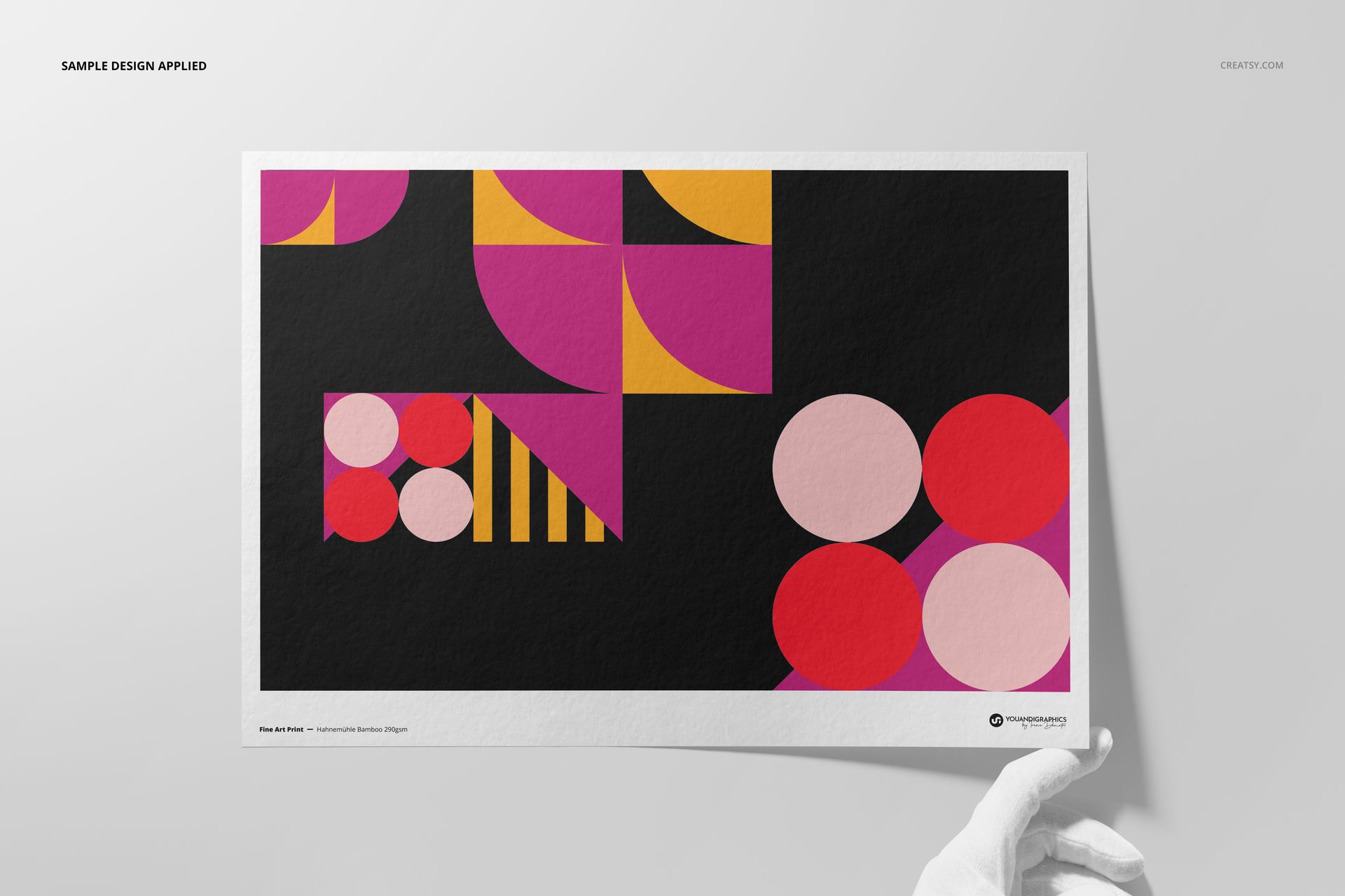A3 fine art print mockup featuring geometric shapes in pink, magenta, yellow, and black, held by a gloved hand.