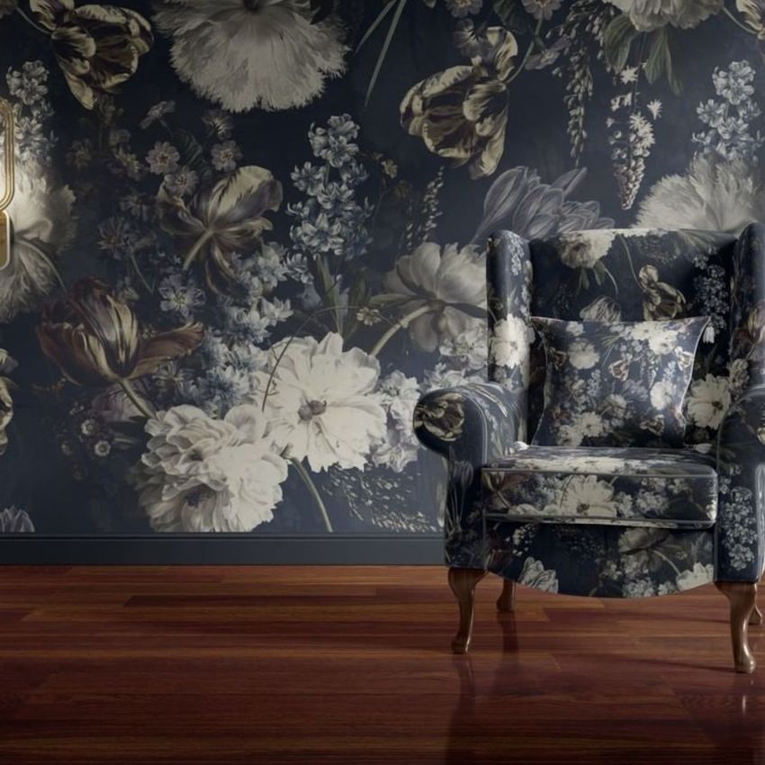 Retro velvet armchair mockup featuring a dark floral pattern, placed on wooden flooring against a matching floral wallpaper.