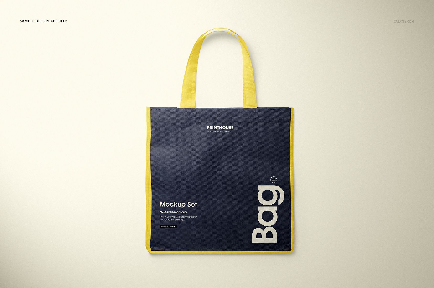 Front view of a non-woven tote bag mockup with yellow handles and edges, featuring a dark blue body on a neutral background.