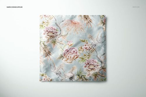 Top view of a polyester cushion cover mockup featuring pink peonies and cranes on a pale blue background.