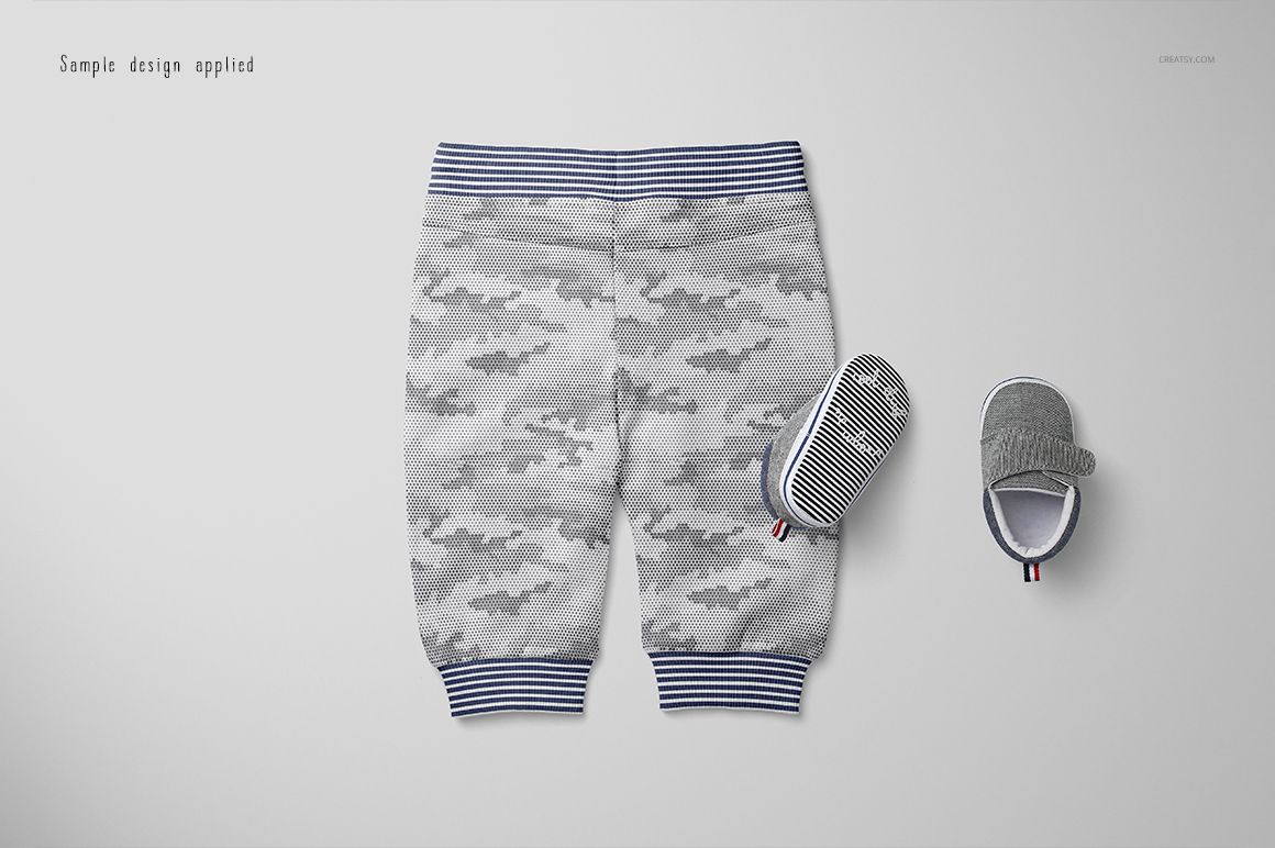 PSD mockup showing baby sweatpants in gray camo with blue striped cuffs, displayed beside matching baby shoes.