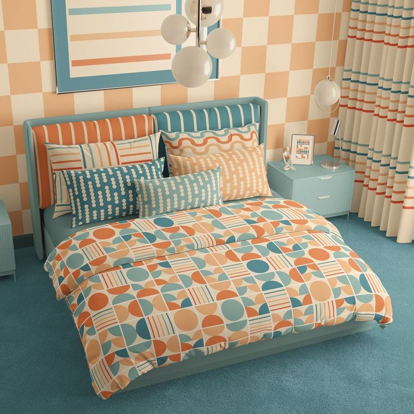 Bedroom scene bedding mockup showing a bed with geometric patterned duvet and pillows in orange, blue, and beige tones.
