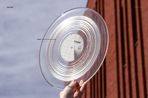 Transparent vinyl record mockup held up against the sky, with a brick building in the background and visible label.