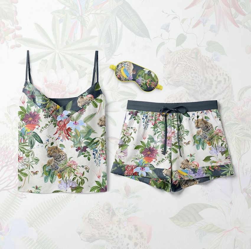 Short silk pajama mockup set featuring a camisole, shorts, and sleep mask with a colorful jungle and leopard pattern on a light background.