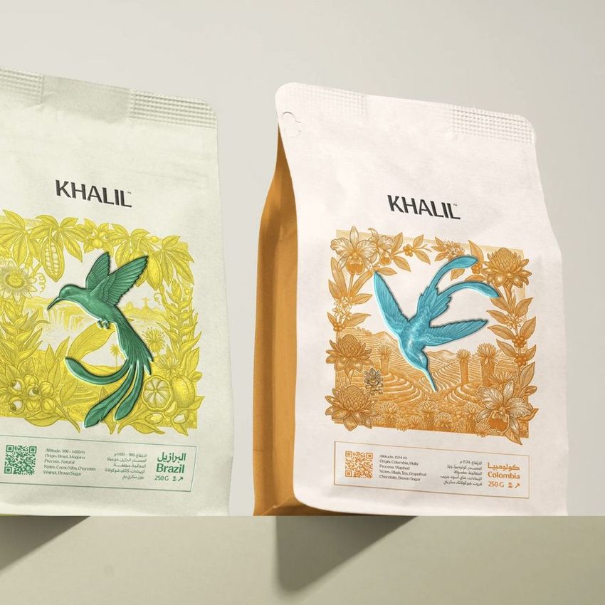Coffee bag mockup featuring two upright packages with illustrated hummingbirds and floral designs on a neutral background.