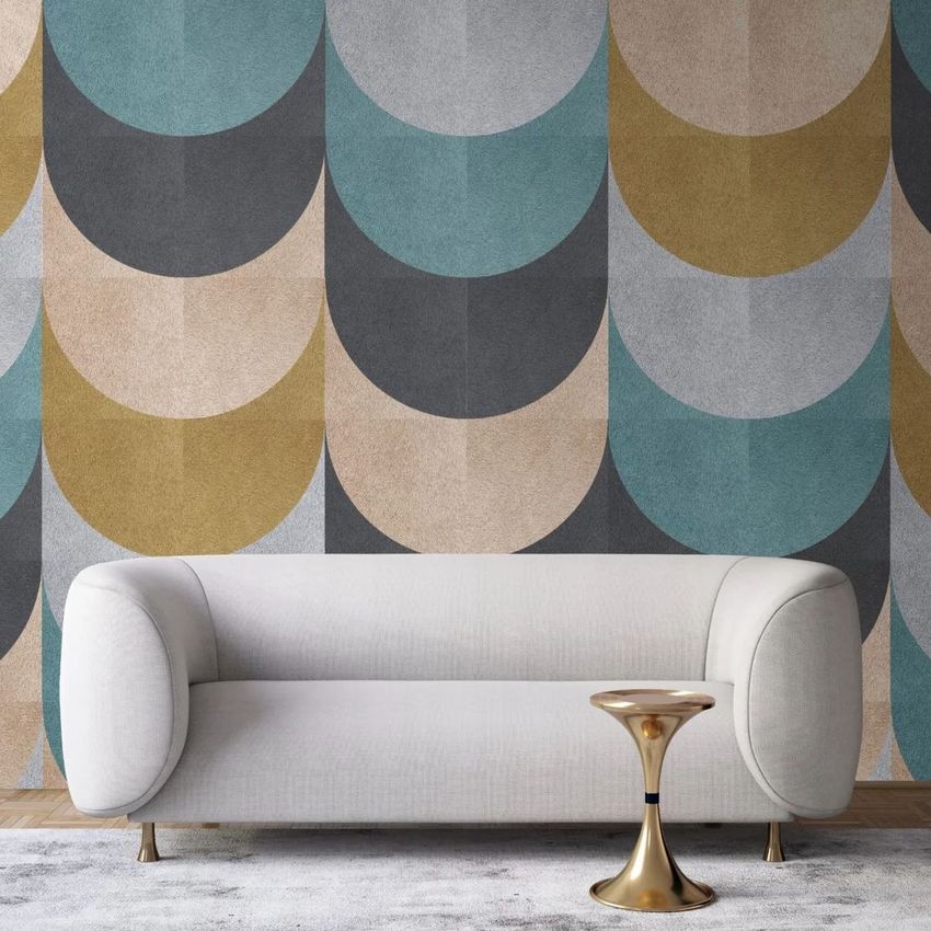 Poster mockup showing a light gray lounge sofa in front of a wall with large geometric shapes in blue, gold, and gray tones.