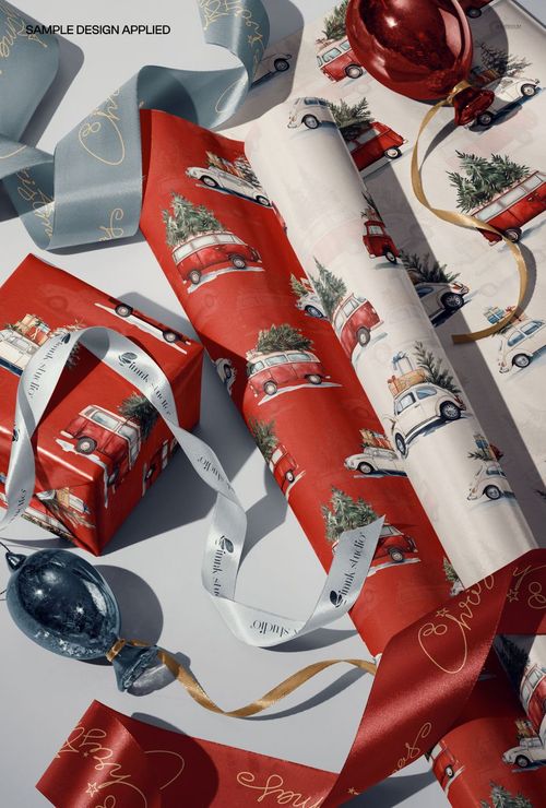 Christmas gift wrap rolls and ribbons mockup featuring red and white paper with vintage car and tree patterns.