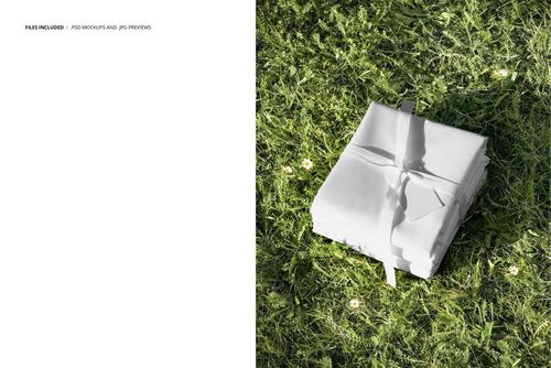Spring fabric PSD mockup showing a neat stack of white cloth on vibrant green grass with tiny flowers.