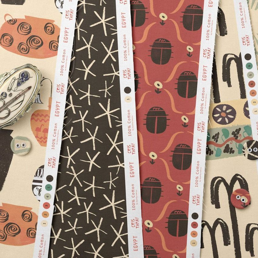 Cotton fabric sample mockup showing multiple patterned fabric strips with abstract and geometric designs in earthy tones, viewed from above.