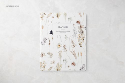 Front view of a stationery planner with a floral pattern cover, placed on a light marble surface in a mockup scene.