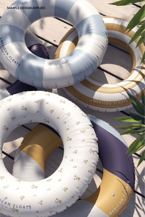 PSD mockup of inflatable swim rings featuring various designs and soft shadows on a bright outdoor pool deck.