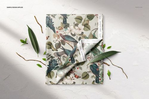 Botanical-themed folded fabric mockup featuring birds and flowers, shown on a white background with natural props.