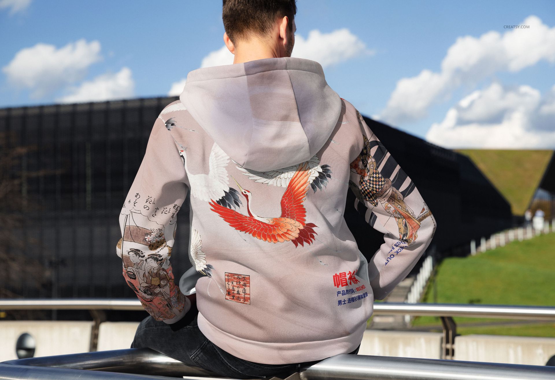 Oversized hoodie with large hood mockup shown outdoors, featuring colorful crane and graphic patterns on the back.