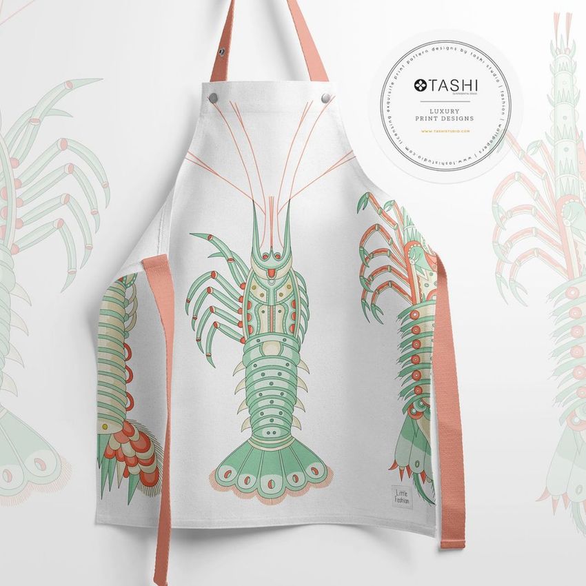 Kids apron mockup featuring a white apron with a colorful crab illustration, displayed flat against a light background with peach straps.