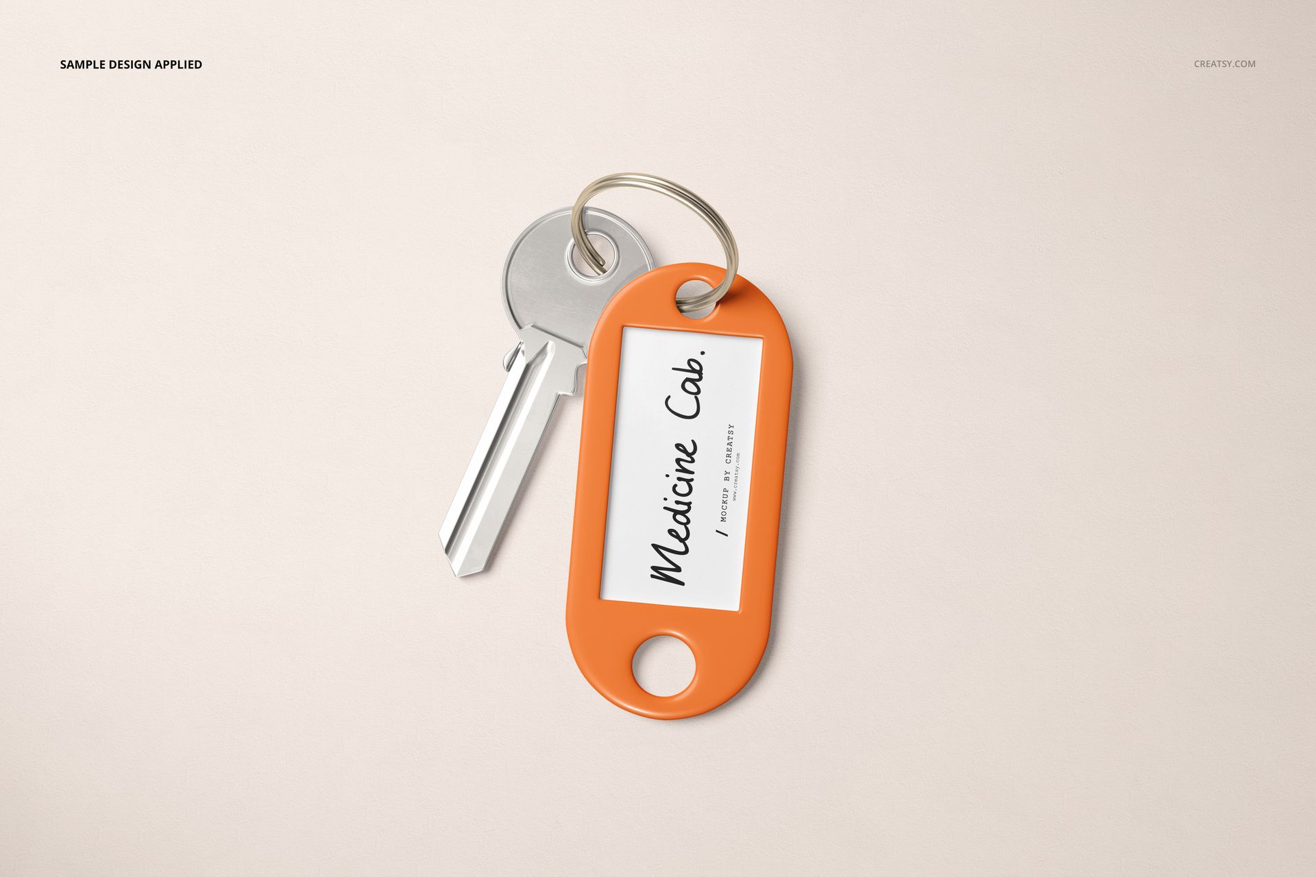 Key tag mockup featuring a silver key attached to an orange oval key tag with a white label, shown from above.